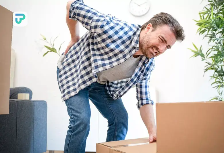 فردی در حال بلند کردن جسم سنگین که به ناگاه کمرش رگ به رگ می شود و نیاز به درمان رگ به رگ شدن کمر در خانه دارد| توان مارکت